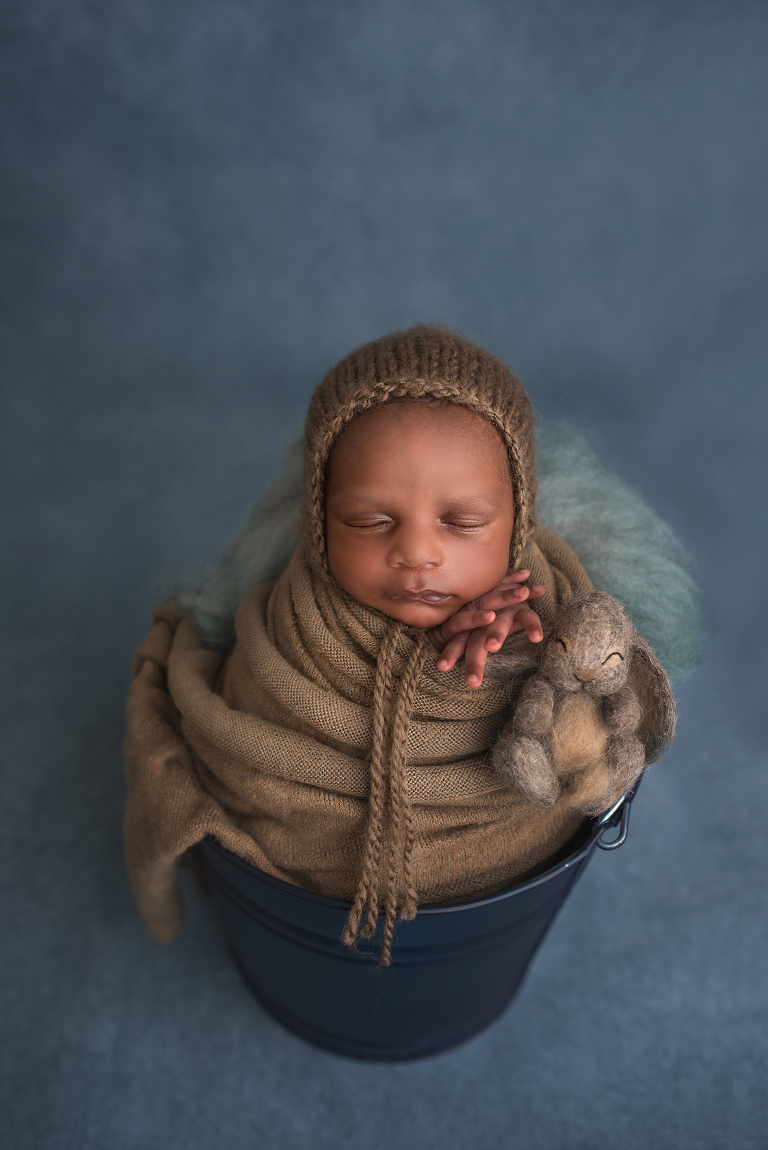 Beautiful newborn baby boy in blue bucket